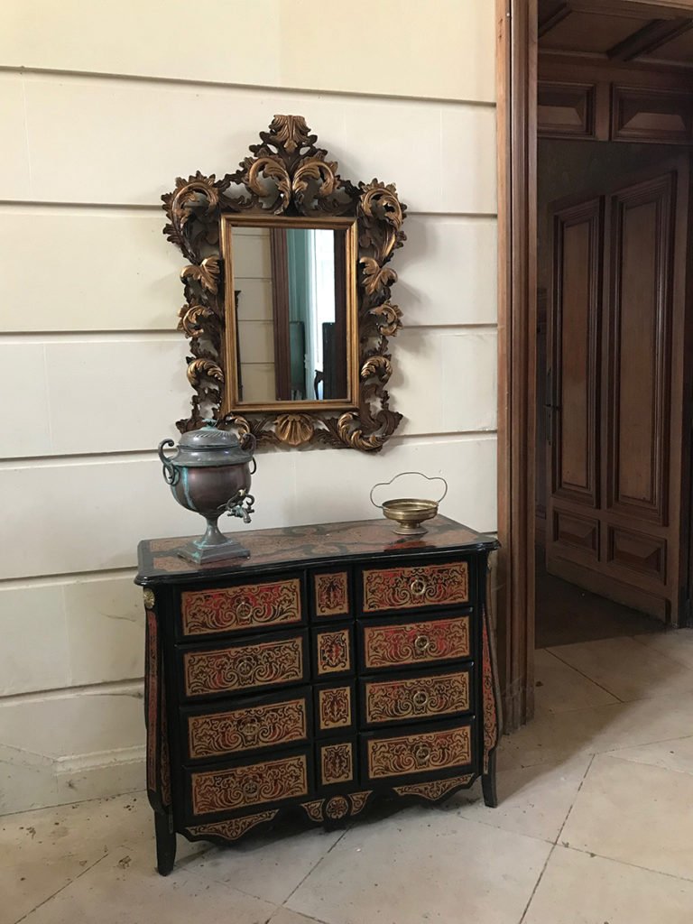 miroir et commode dans la grande entrée d'un château abandonné, urbex