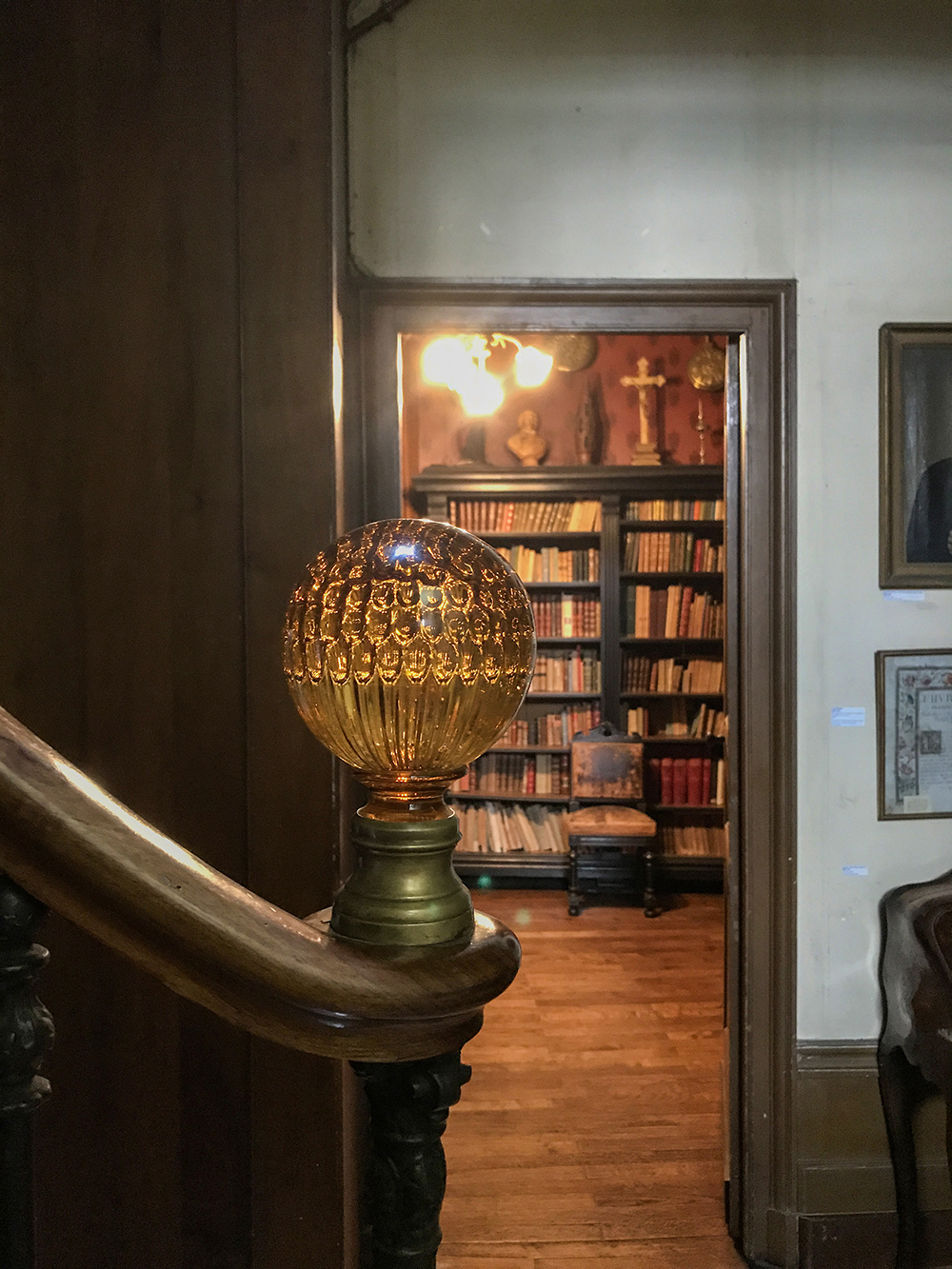 détail de boule d'escalier et vue sur entrée du bureau de Jean George